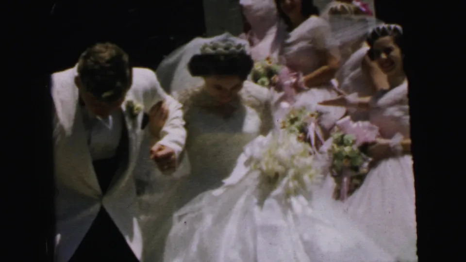 1964 Camden wedding frame with the bride and groom in the foreground and bridesmaids in pink dresses visible behind them.