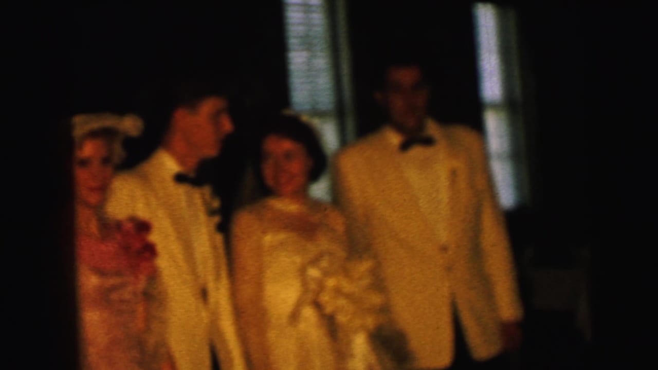 The Camden wedding group remains posed indoors, with the bride and groom centered between a bridesmaid and another tuxedoed man.
