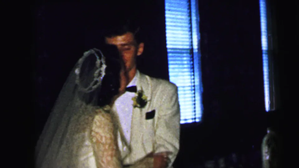 The bride turns toward the groom after the kiss in this 1964 Camden wedding home-movie frame.