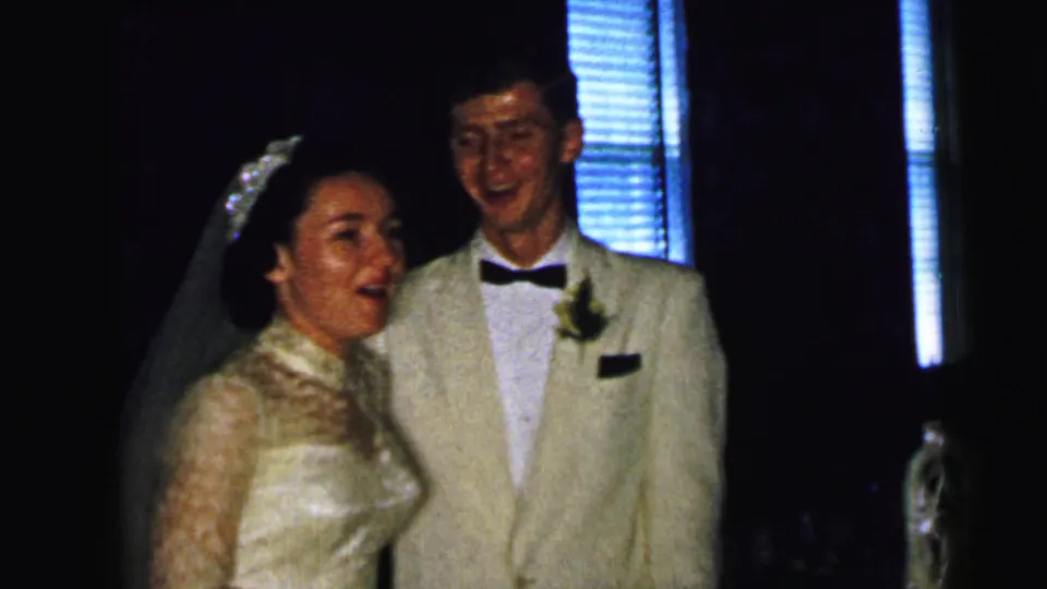 The bride and groom smile together after the kiss in a 1964 Camden, New Jersey wedding home movie.