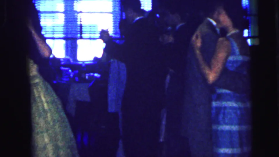 Dim 1964 Camden wedding reception view with multiple adults dancing under blue-tinted indoor light.