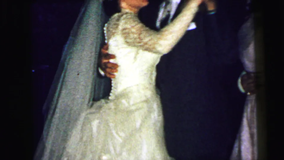 Close view of the bride in a white lace gown and veil dancing with the groom at a 1964 Camden wedding reception.