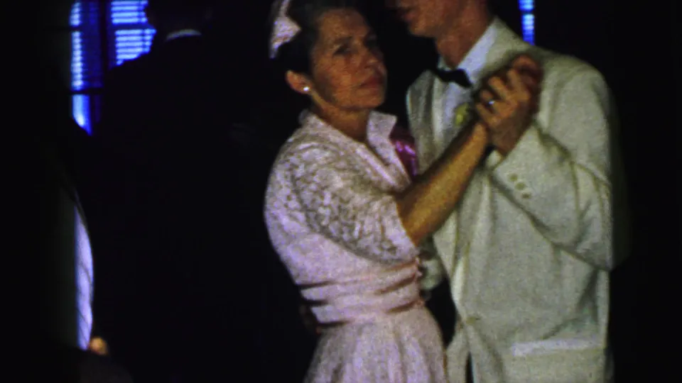 In the final frame, the Camden formal-dance couple faces the camera more clearly, holding hands as blue ambient light appears behind them.
