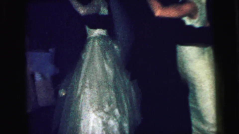 In 1964 Camden, New Jersey footage, young formal-dressed couples appear close together on a dark dance floor.