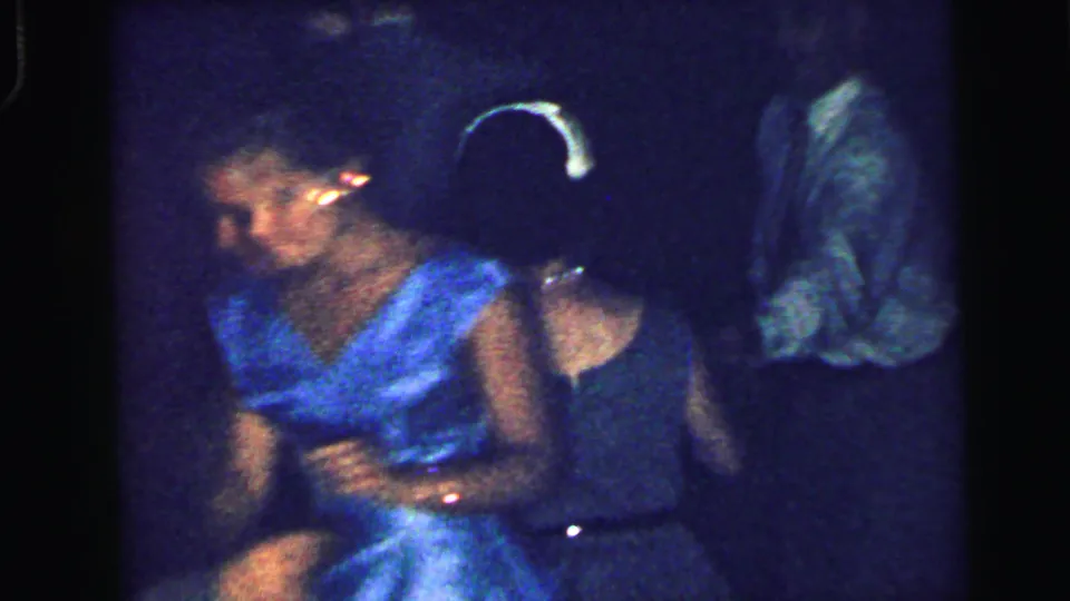 A woman in a bright blue dress dances near other adults in suits and dark formalwear at the Camden gala.