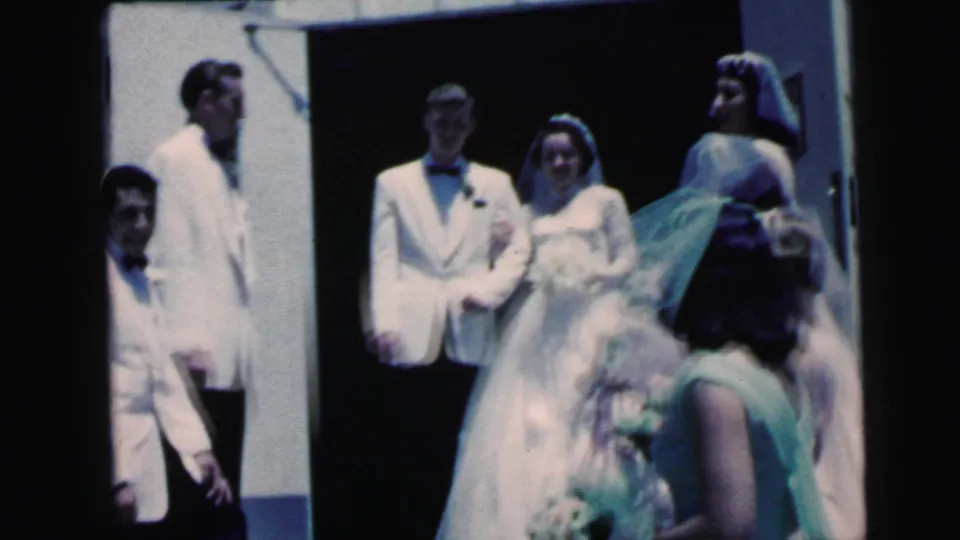 Camden wedding frame showing bride and groom posed at the entrance with attendants nearby, captured on color 8mm home-movie film.