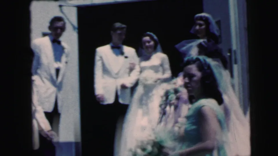 1964 Camden wedding scene with the bride and groom in the doorway and a bridesmaid carrying flowers in front.
