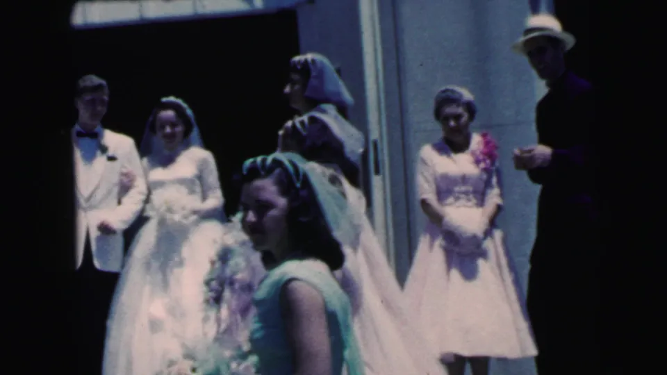 Camden, New Jersey wedding party in 1964, showing bride, groom, bridesmaid, and guests clustered near the entrance.