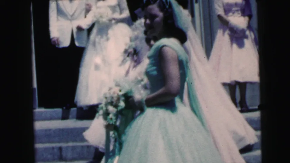 1964 Camden wedding footage showing the bride in white and a mint-dressed attendant near guests on church steps.