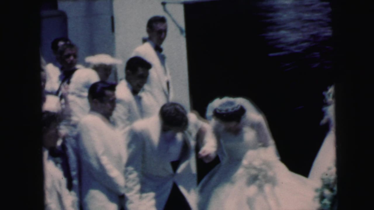 Bride, groom, and wedding guests are seen outside a Camden church in a faded 1964 8mm home-movie frame.