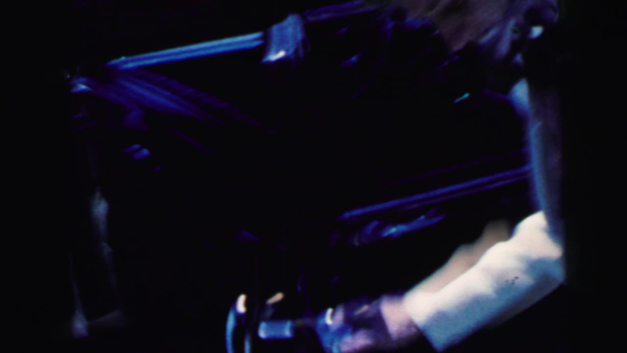 1964 Camden home-movie frame showing a bride and groom entering or shifting into a dark car at night.