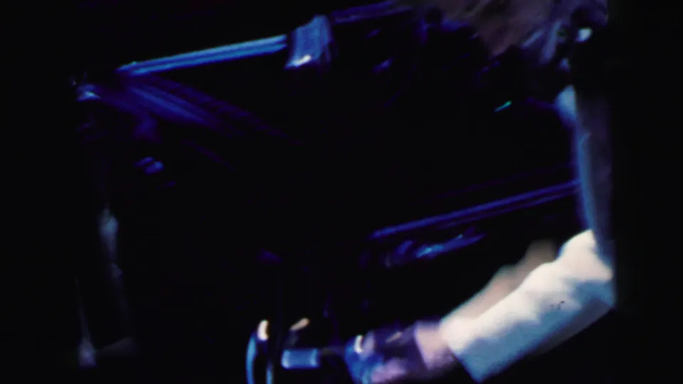 1964 Camden home-movie frame showing a bride and groom entering or shifting into a dark car at night.