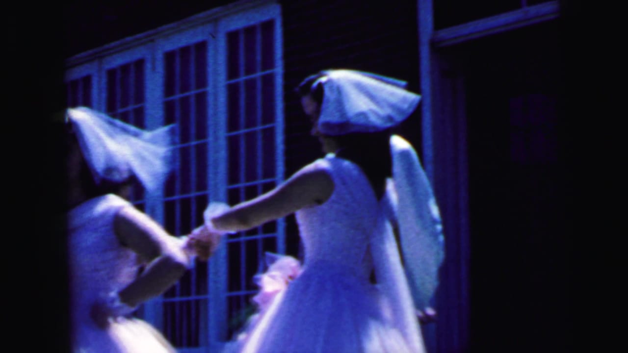 1964 Camden wedding footage shows veiled attendants in white dresses moving together outside a brick building.