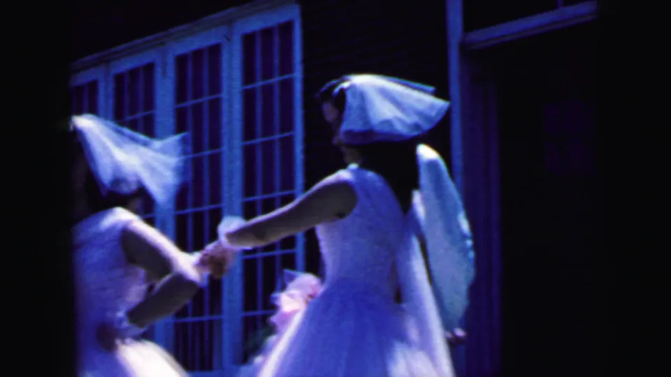 1964 Camden wedding footage shows veiled attendants in white dresses moving together outside a brick building.