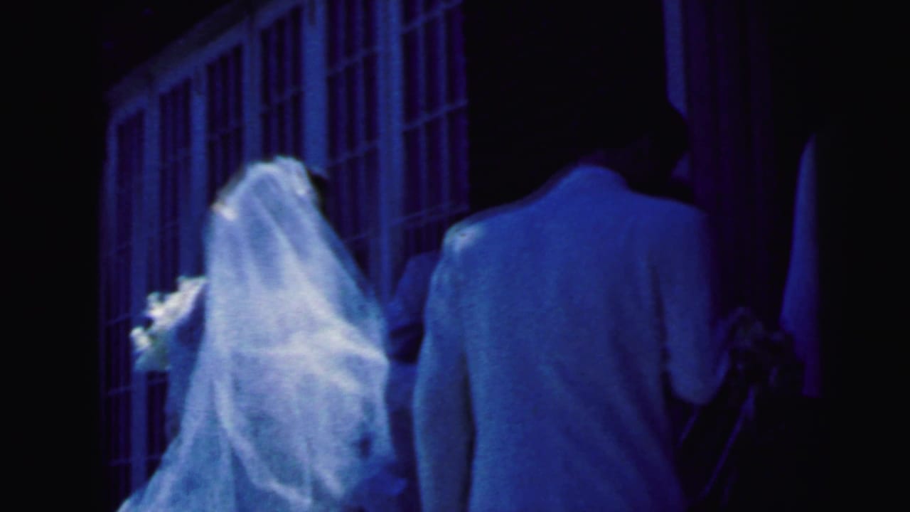 The bride and groom approach a Camden church doorway in a blue-tinted 1964 8mm wedding home movie.
