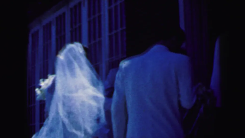 The bride and groom approach a Camden church doorway in a blue-tinted 1964 8mm wedding home movie.