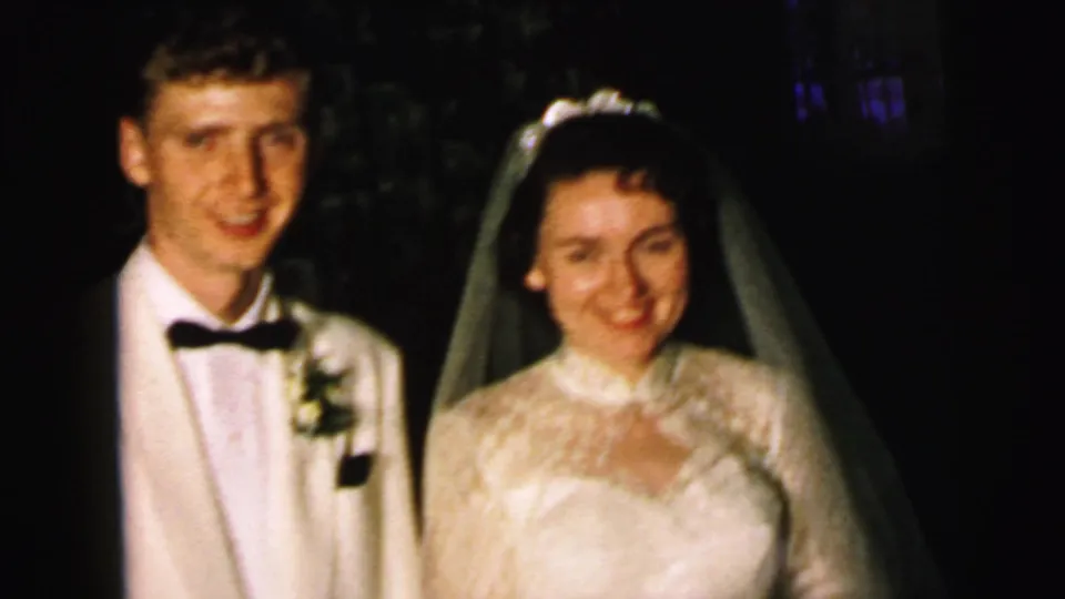 The Camden bride and groom remain posed for the 8mm camera, with veil, lace gown, boutonniere, and bow tie visible.