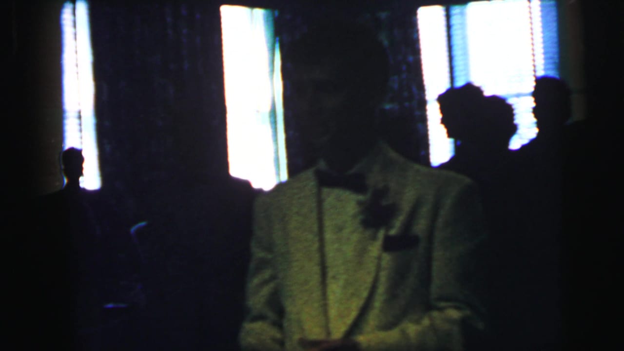 The formal-event scene continues with a white-jacketed man at right and dark guest silhouettes against bright interior windows.