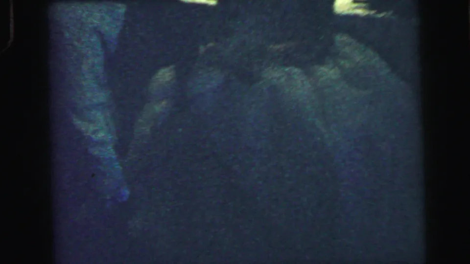 1964 Camden, New Jersey 8mm wedding footage showing a suited man leaning near a bride's white dress in very low light.