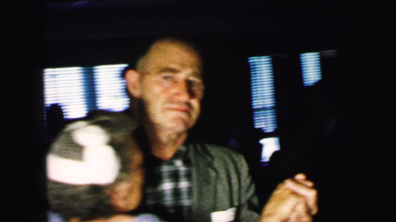 An older male guest in a plaid shirt and jacket dances close to a partner during the Camden wedding reception.