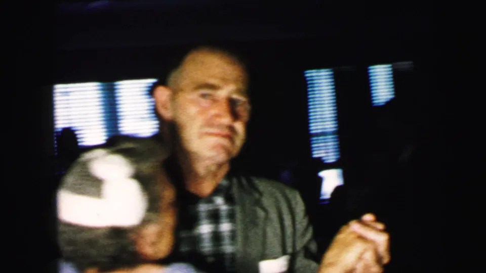 An older male guest in a plaid shirt and jacket dances close to a partner during the Camden wedding reception.
