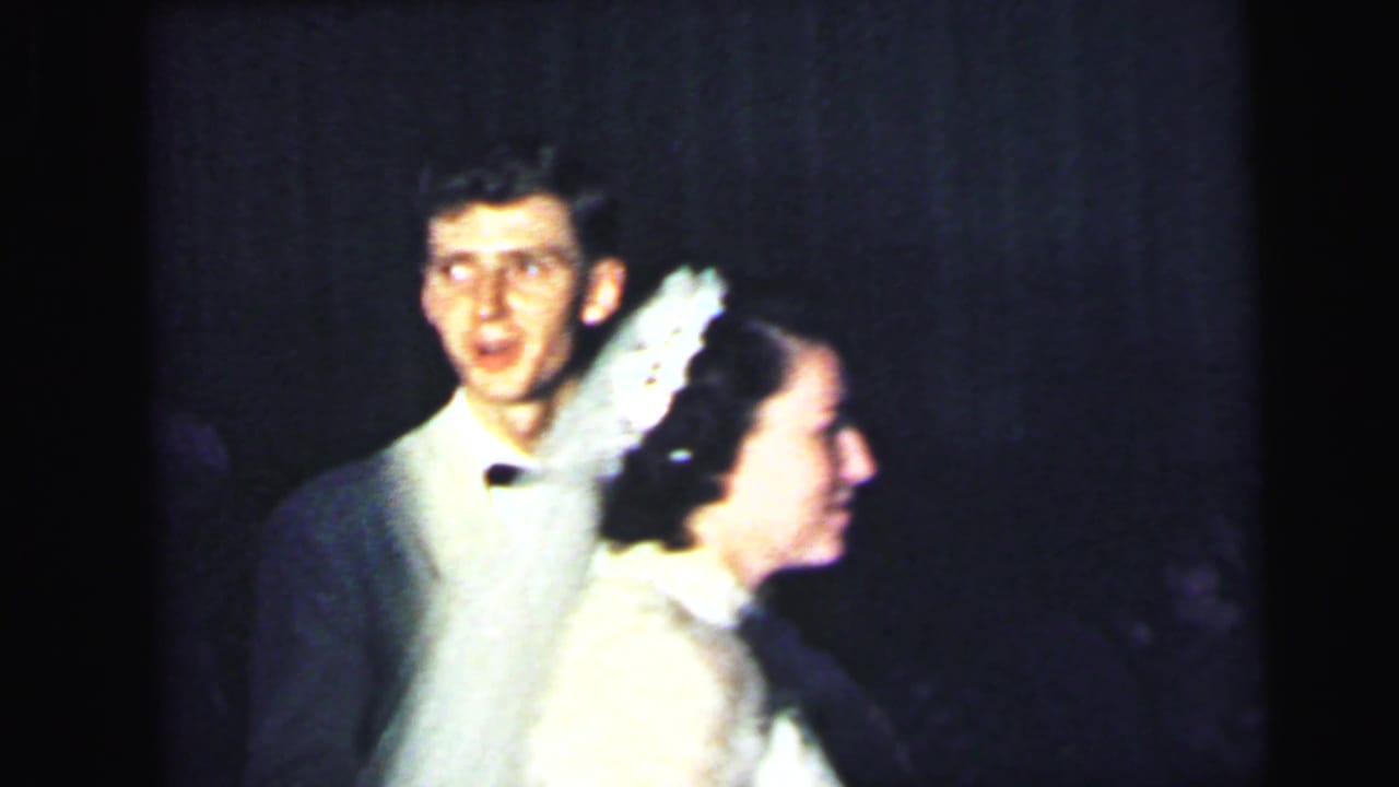 The bride and groom appear together at the 1964 Camden reception, with the groom in a white jacket and the bride in a veil and lace dress.