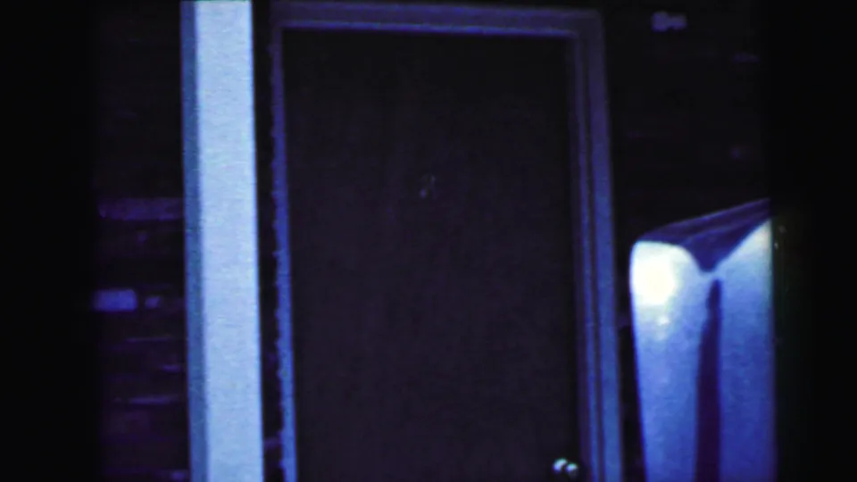 Close view of a dark doorway marked with the number 8, beside white trim and the edge of a parked car in Camden footage.