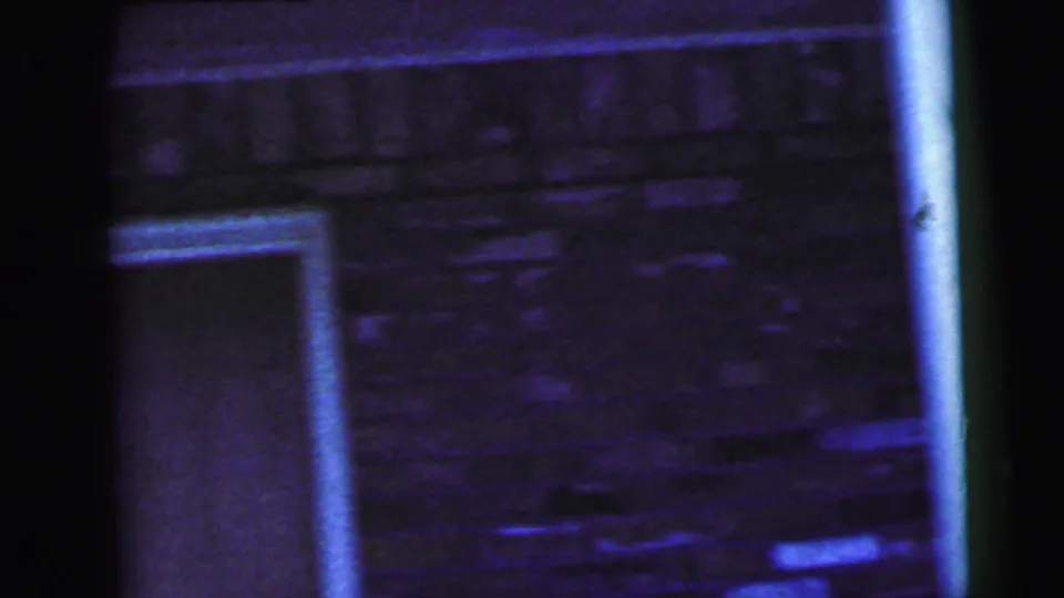 Soft, grainy close-up of brick wall and doorway detail at the Camden motel exterior in the stated 1964 home movie.