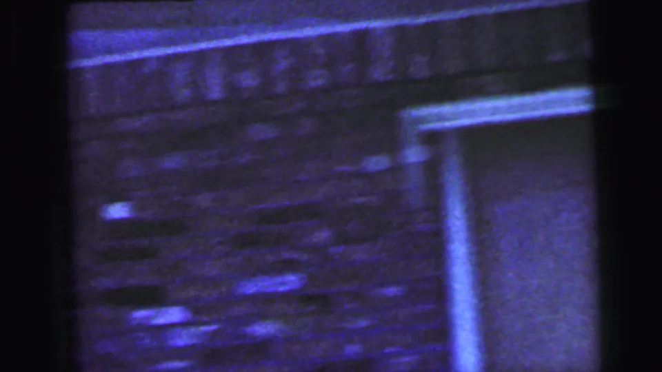 Soft, blue-shifted 1964 Camden frame showing a brick exterior wall, doorway, and heavy 8mm film edges.