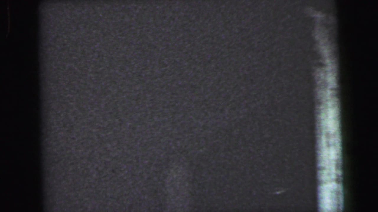 Near-dark 8mm film frame at the start of a handheld interior pan, Camden, New Jersey, circa 1964