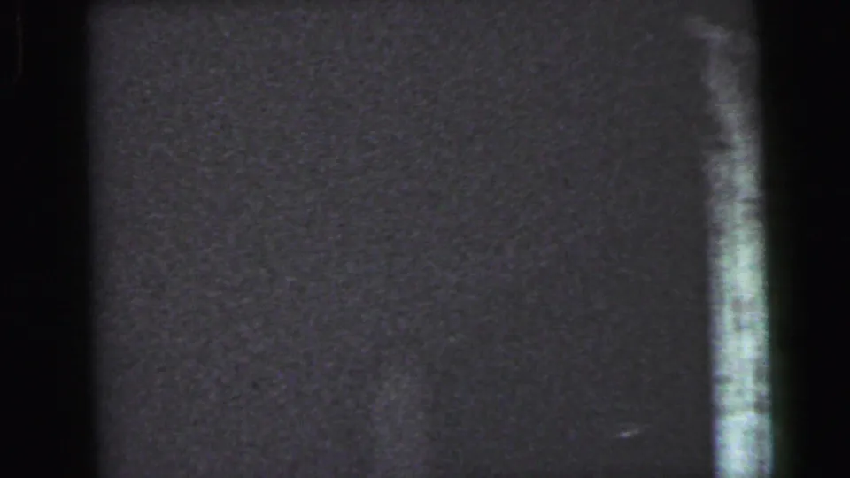 Near-dark 8mm film frame at the start of a handheld interior pan, Camden, New Jersey, circa 1964