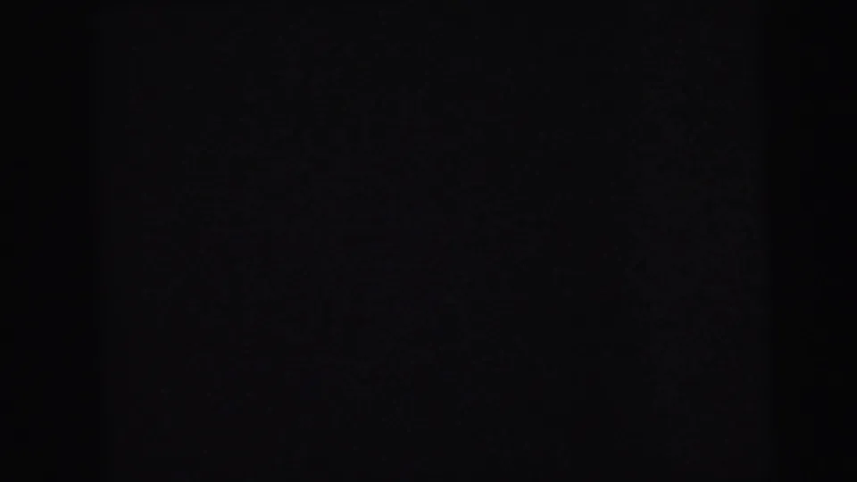 Near-black 8mm film frame during a handheld pan through a dark interior, Camden, New Jersey, circa 1964