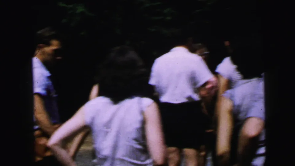 Group of adults in summer casual wear mingling at an outdoor gathering, mid-1960s 8mm home movie, likely Camden, New Jersey.