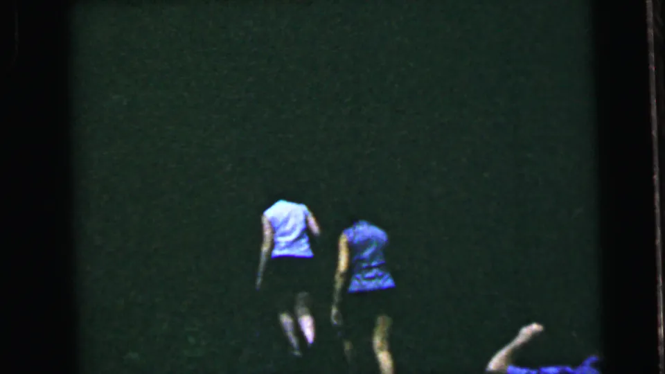 Two women in mid-1960s summer clothing walking away from camera across a grassy lawn; 8mm home movie, United States, circa 1964.
