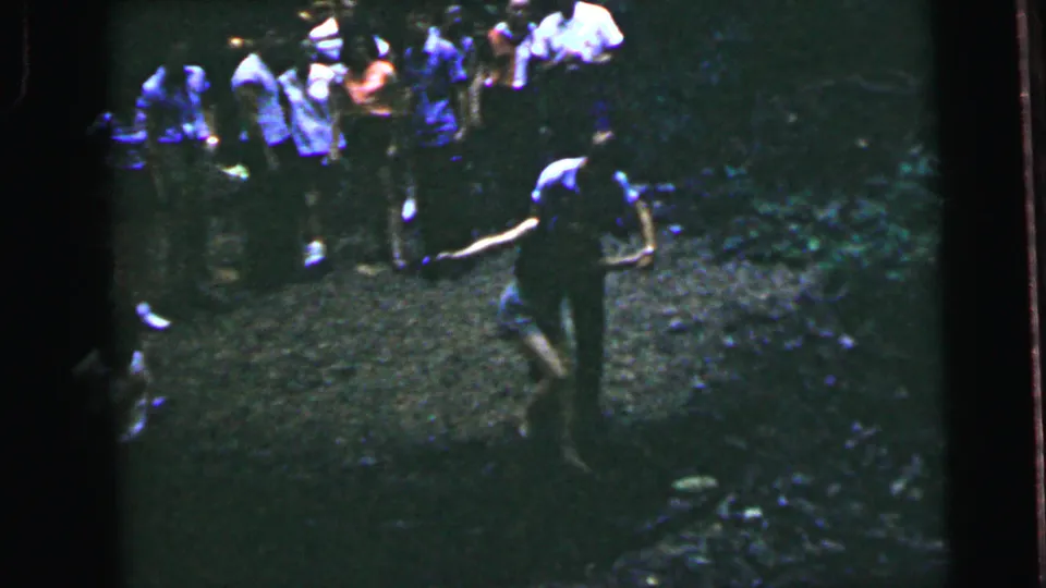 Several adults in casual summer clothing walk along a shaded woodland path in what may be a New Jersey forest, 8mm home movie footage circa 1964.