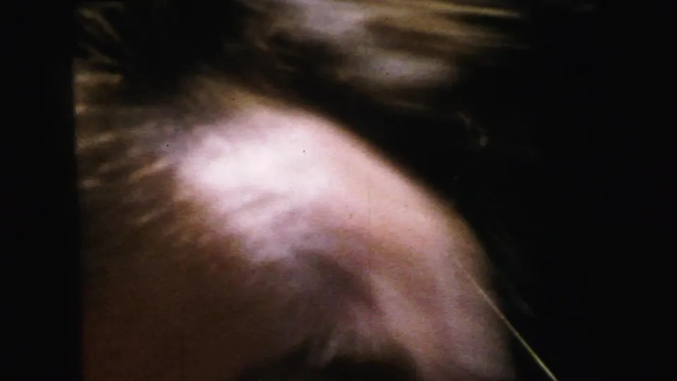 Extreme motion blur producing an abstract pinkish frame, possibly a camera whip or accidental skin-tone close-up at the clip's end, circa 1964.