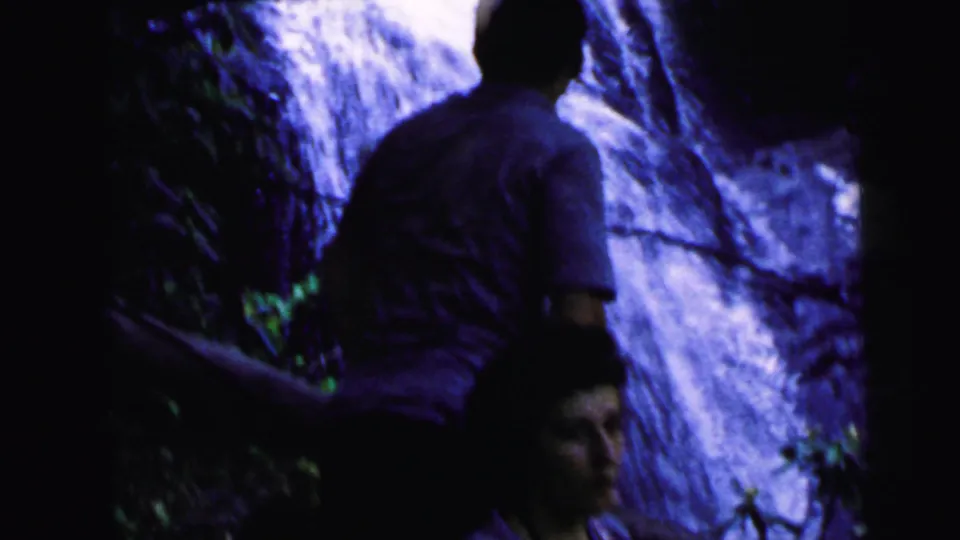 Man and woman beside a rocky waterfall shot from behind, 8mm home movie circa 1964, Camden, New Jersey