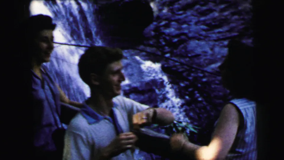 Young man and woman in early-1960s summer clothing at waterfall base; 8mm home movie, Camden New Jersey, 1964.