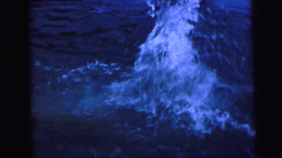 Blue pool water erupts in a tall central splash plume at the moment of belly flop impact, in this 8mm home-movie frame from a 1964 backyard pool sequence.