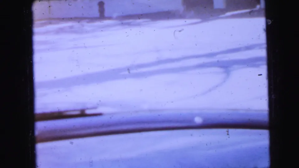 Blue-toned 8mm exterior frame showing a pale flat surface with diagonal structural lines, possibly a rooftop, from a 1964 Camden home movie.