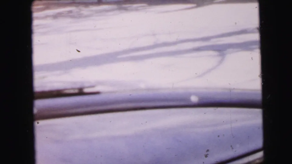 Pale exterior surface — possibly roofing or architectural detail — with diagonal structural lines, from a 1964 8mm home movie in Camden, New Jersey.