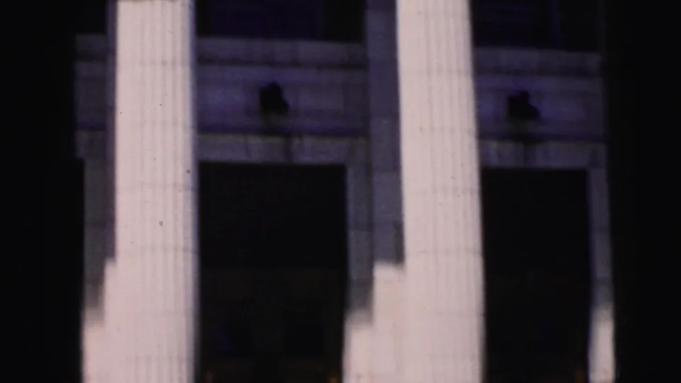 Neoclassical courthouse colonnade at close range showing fluted white columns and recessed shadowed entrances, Camden, New Jersey, 1964, 8mm film