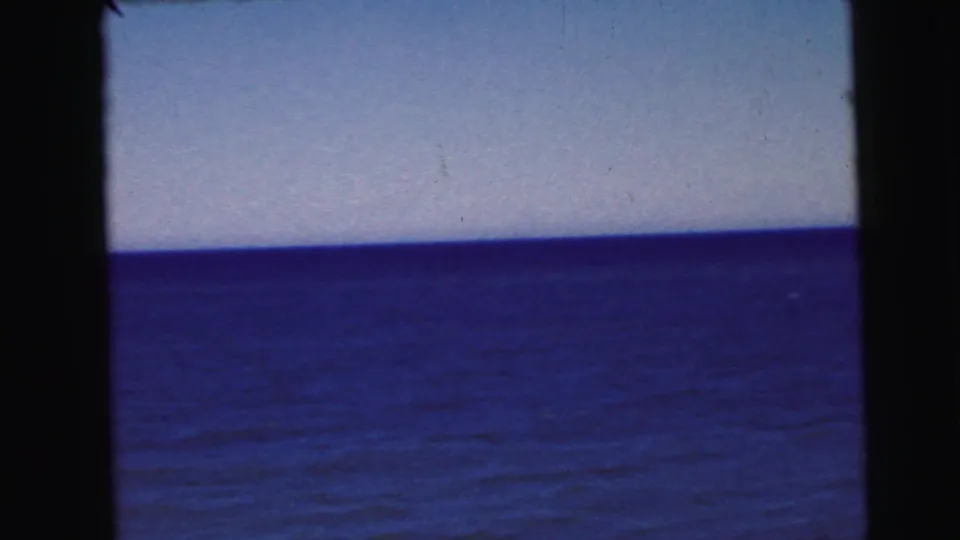 8mm home movie frame, circa 1964, showing an unobstructed panoramic view of wide blue-purple water and pale sky, consistent with mid-Atlantic waterfront footage.