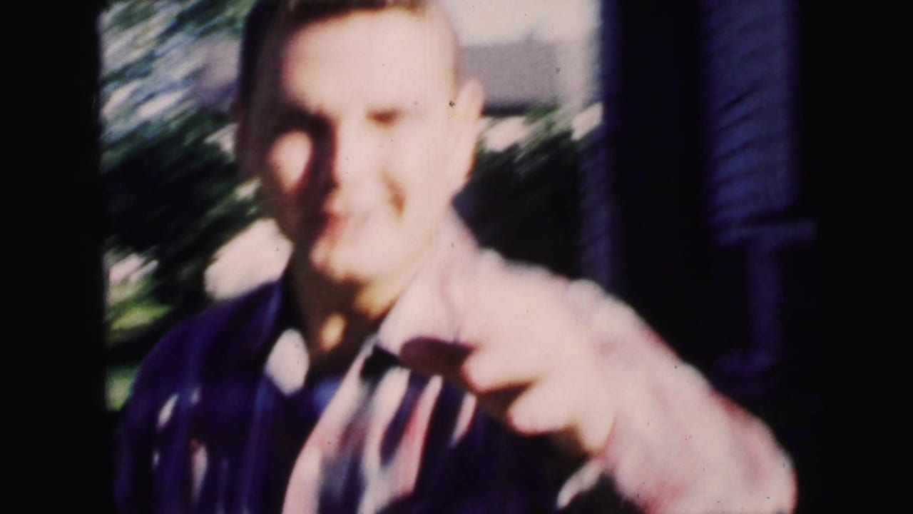 Young man close to the camera on a sunny residential sidewalk.