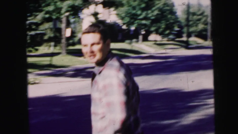 On a Camden residential sidewalk, the young man turns toward the camera as trees and a quiet street fill the background.