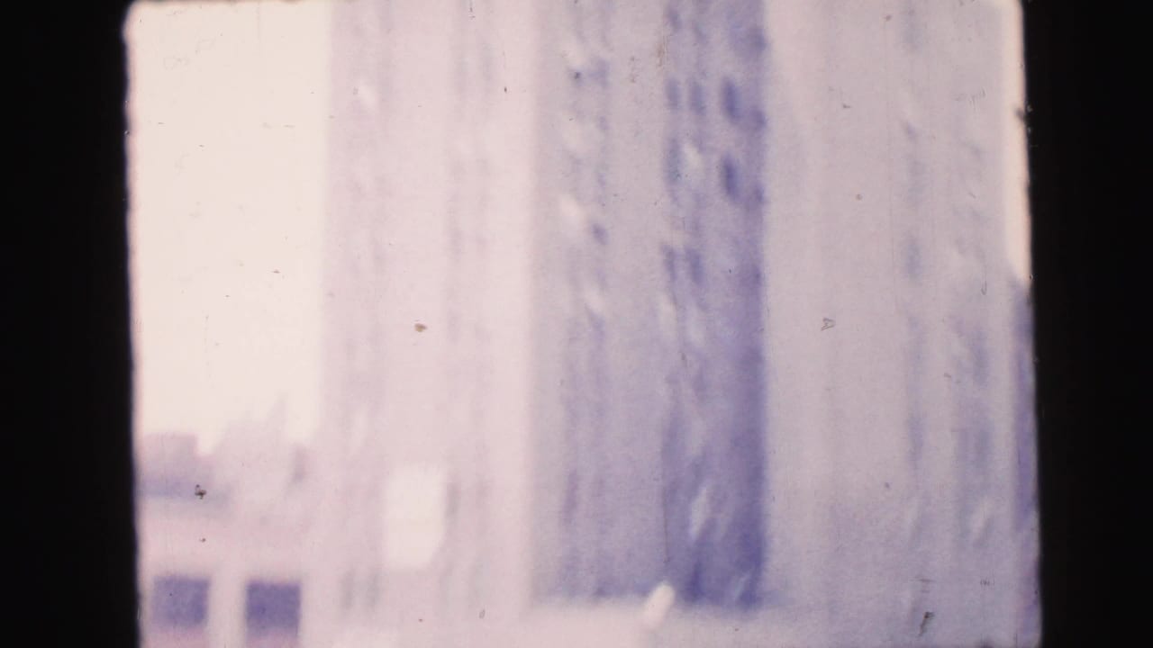 1964 Camden street view with a pale multi-story building facade seen through a dark interior window edge.