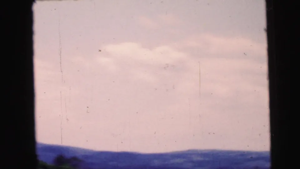 End frame from the 1964 Camden, New Jersey metadata set showing a soft sky and low hill line on 8mm film.