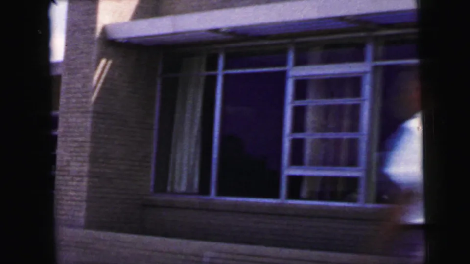 Large-window brick building glimpsed from 1960s 8mm travel footage, likely in the Camden, New Jersey clip context.