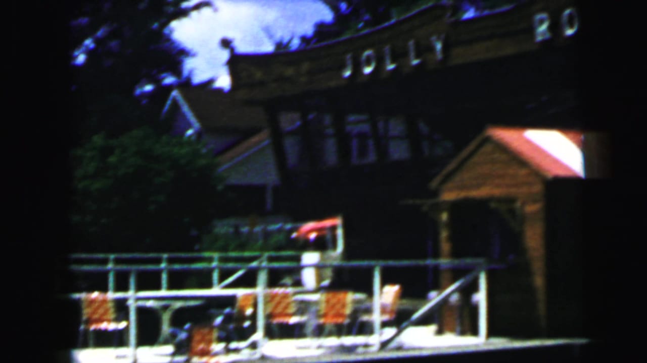 Camden, New Jersey dock area with Jolly Roger signage above a waterfront deck, railings, chairs, and nearby water.