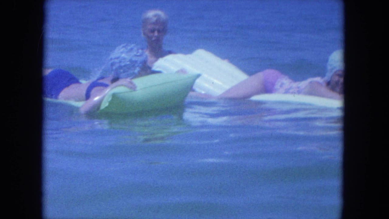 1964 Clearwater frame with women on pool floats in blue-tinted water, bordered by visible 8mm contact-sheet edges.